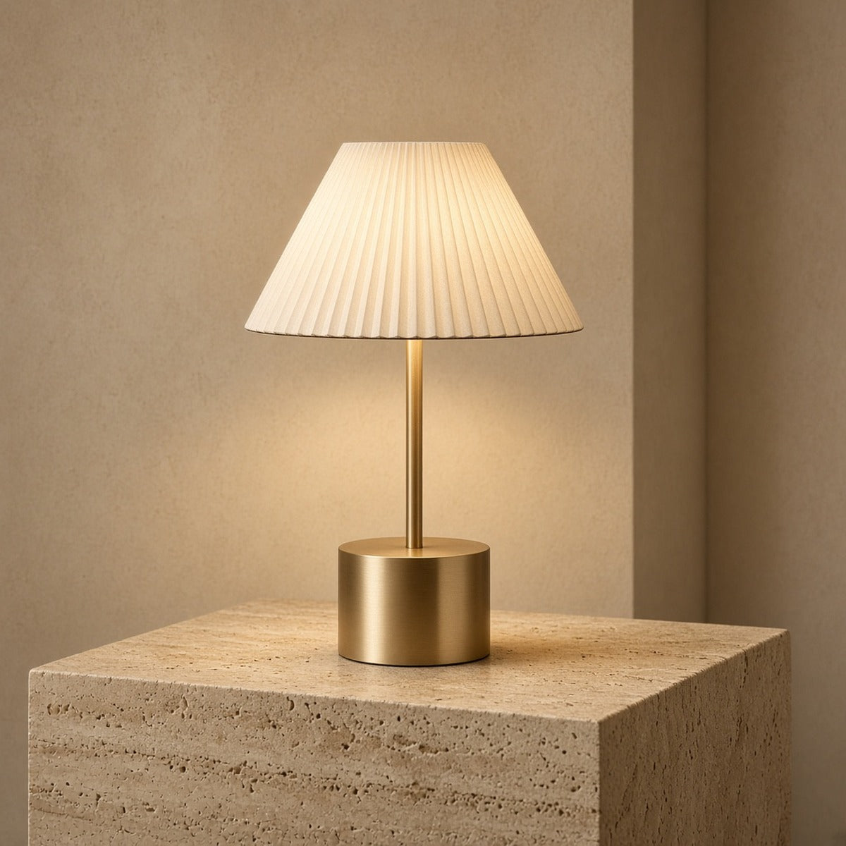 Aetheris Atelier Cordless Brushed-Brass and Pleated Alabaster Architectural Table Lamp casting warm 2700K pool of light on travertine surface