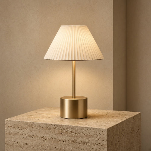 Aetheris Atelier Cordless Brushed-Brass and Pleated Alabaster Architectural Table Lamp casting warm 2700K pool of light on travertine surface