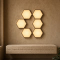 Aetheris Atelier Modular Hexagonal Touch-Sensitive Warm-Wall Architectural Light Panels arranged on minimalist limestone wall