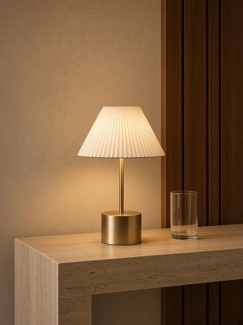 Aetheris Atelier Cordless Brushed-Brass Pleated Table Lamp on travertine credenza with walnut millwork